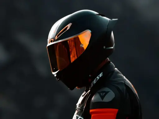 Motociclista con casco negro y visor naranja, listo para la acción. El uso obligatorio de casco es clave para la seguridad.