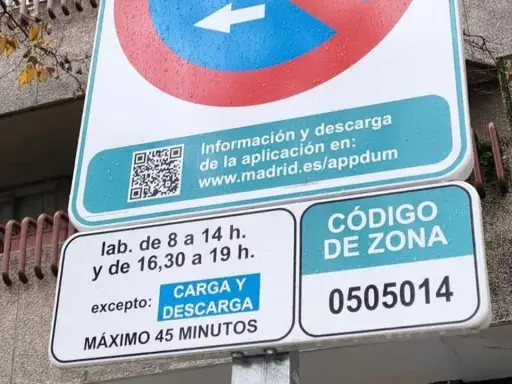 Señal de tráfico de carga y descarga con horarios y código de zona.