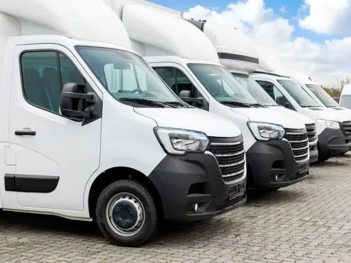 Fila de furgonetas blancas listas para la entrega. El modelo dgt n1 es el primero de la fila, con un diseño moderno y robusto.
