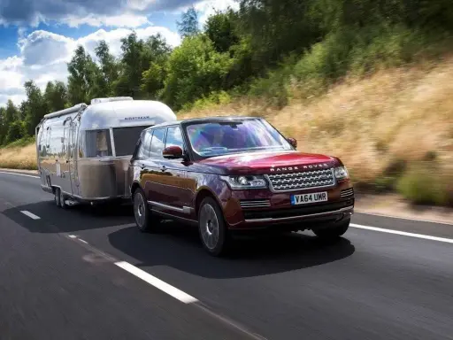 Range Rover rojo arrastra una caravana Airstream. Con el carnet B+E, puedes llevar este tipo de remolque.