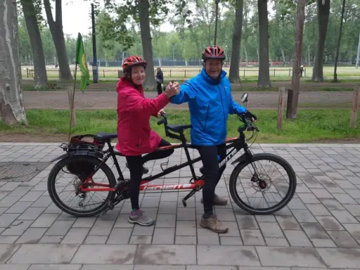 Pareja feliz en un eje tandem triaxial, disfrutando de un paseo en bicicleta por el parque.
