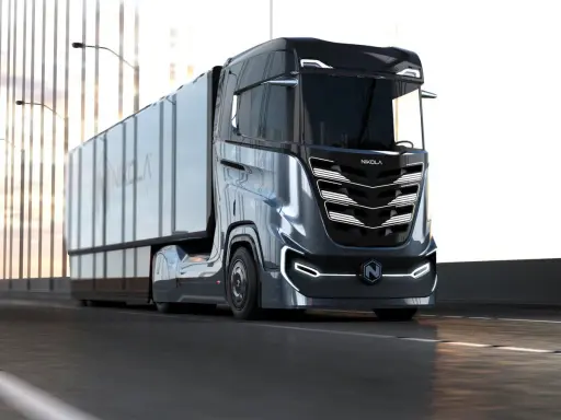 Camión Nikola Tre futurista en carretera, con su diseño aerodinámico y luces LED.