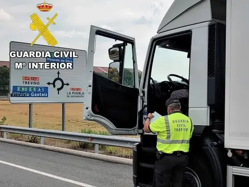 Agente de la Guardia Civil revisa documentación de un camión. Se puede conducir un camión sin tarjeta de transporte si se cumplen ciertos requisitos.