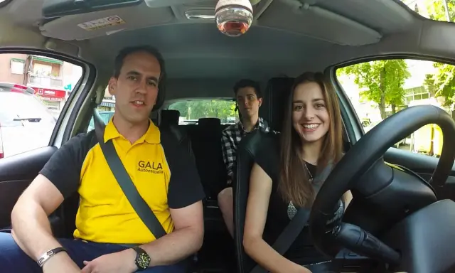 Instructor de autoescuela sonríe junto a dos alumnos en un coche. ¡Listos para el turismo y el aprendizaje!