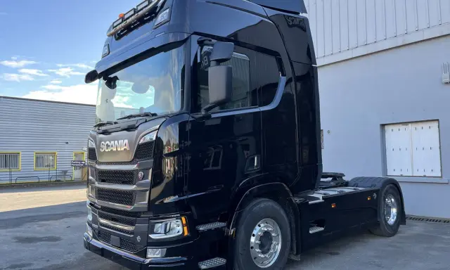 Camión Scania R590 negro brillante, listo para la carretera.