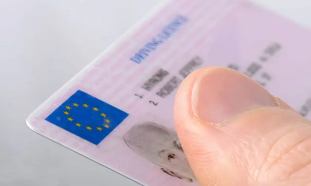Pulgar sobre un carnet de conducir B2 con el logo de la UE.