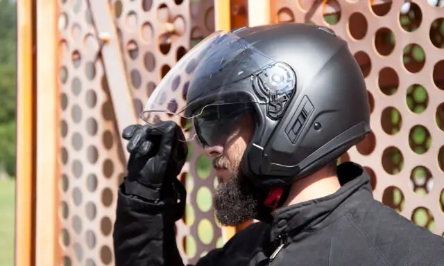 Hombre con barba y casco negro, listo para montar en quad. Es obligatorio llevar casco en un quad para tu seguridad.