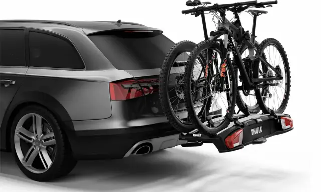Portaequipajes trasero con dos bicicletas de montaña. Señalizar la carga que sobresale de un camión es crucial para la seguridad vial.
