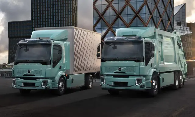 Dos camiones Volvo FE Electric, uno con caja y otro compactador, lucen modernos frente a edificios urbanos.