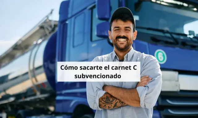 Hombre sonriente con tatuajes, frente a un camión cisterna azul. Aprende cómo obtener tu carnet de camión gratis para desempleados.