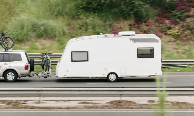 Vehículo todoterreno con remolque caravana y bicicletas, listo para viajar con el permiso de circulación b.