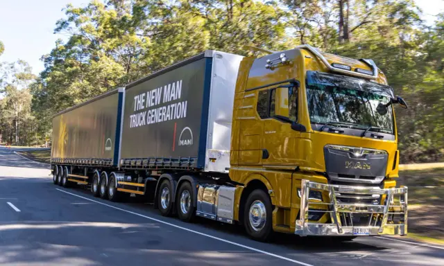 Camión amarillo brillante de MAN en carretera, con el lema "The New MAN Truck Generation". Ideal para mostrar que pueden circular los camiones los domingos.