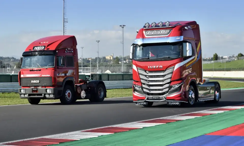 Dos camiones Iveco rojos, uno antiguo y otro moderno, en una pista de carreras.