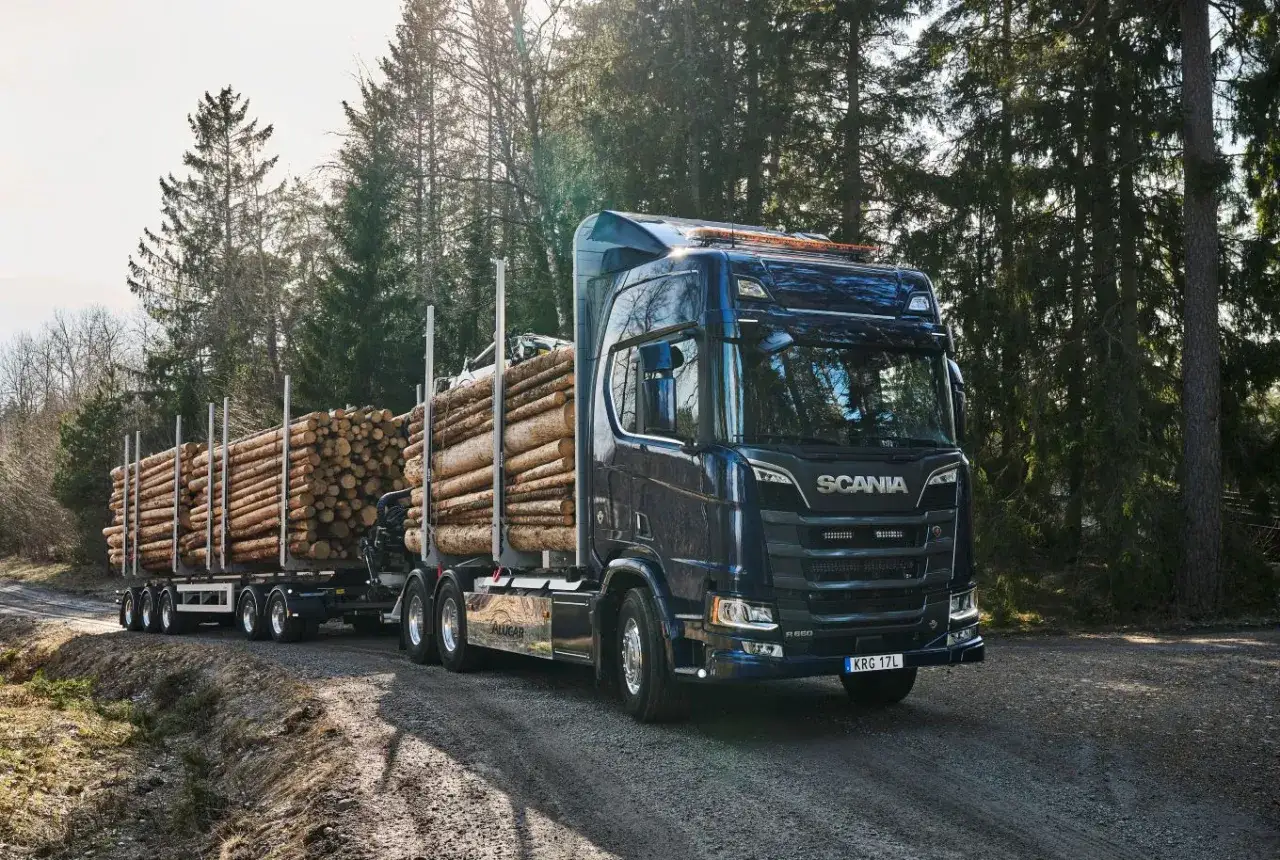 Camión Scania 800 CV transportando troncos por un camino forestal.