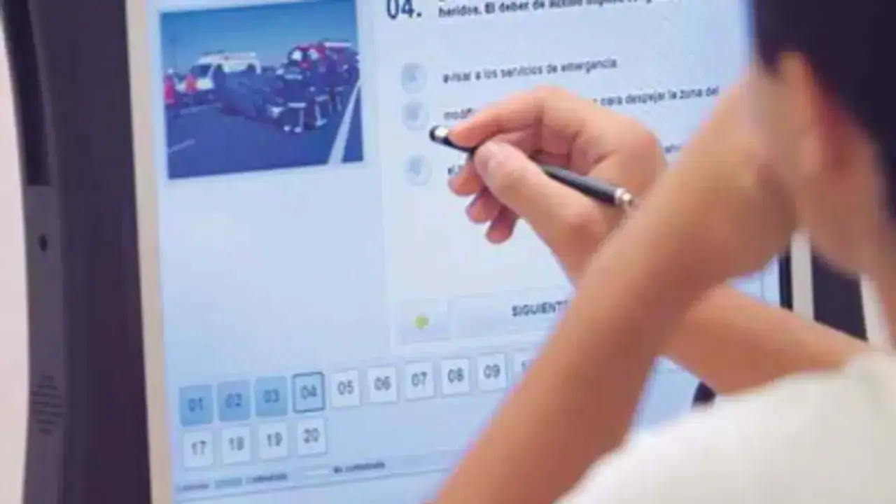 Persona realizando un examen para recuperar el carnet de conducir, con imagen de accidente y preguntas en pantalla.