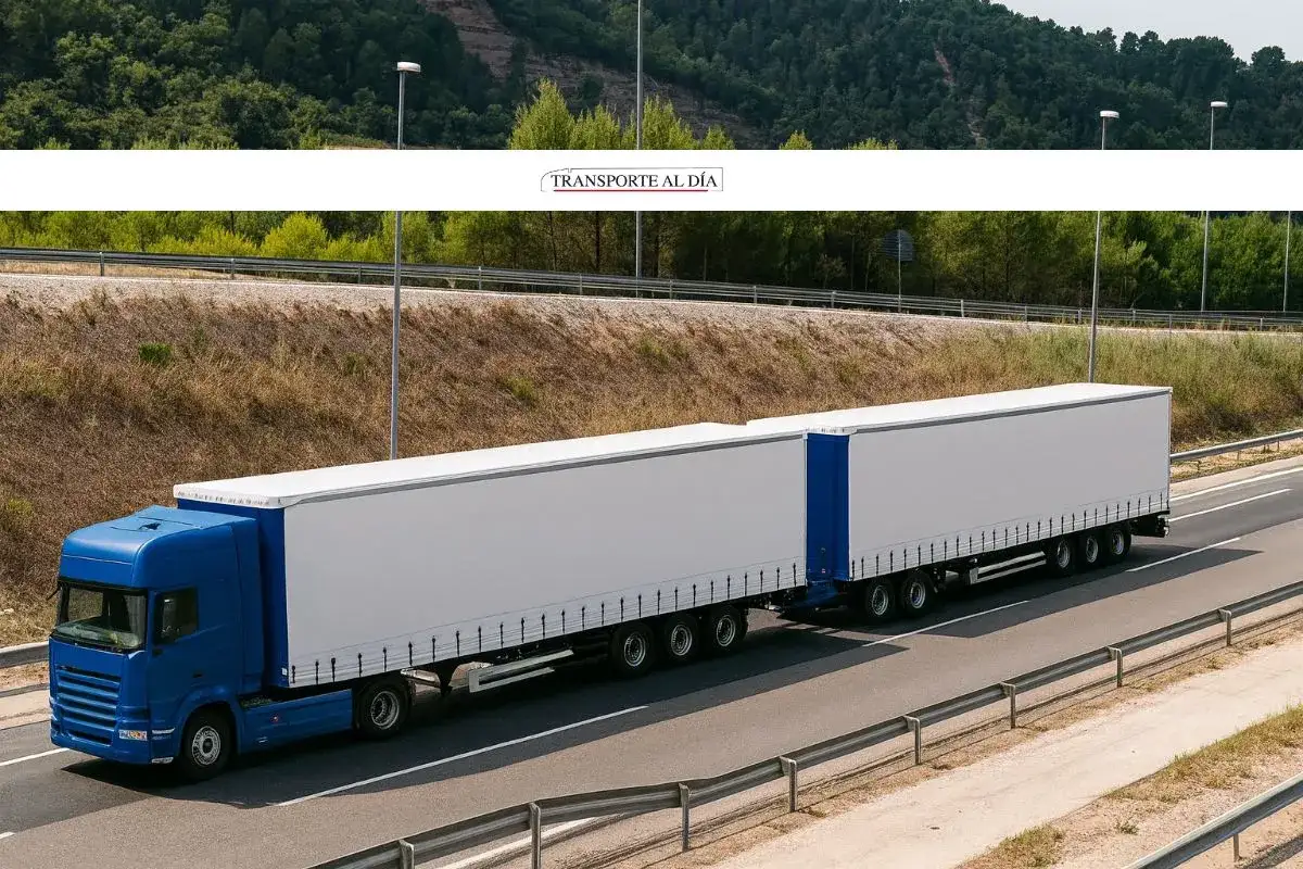 Camión euromodular azul de dos remolques blancos circulando por una carretera.