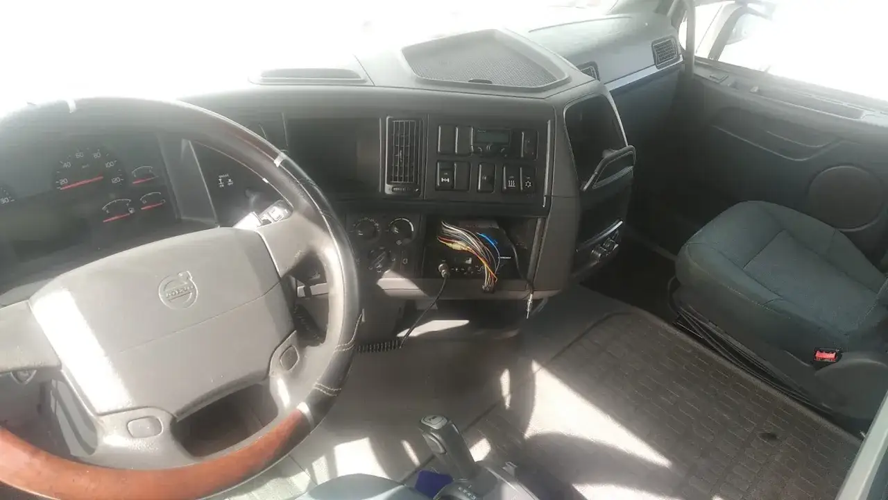Cabina de un Volvo Globetrotter. Volante, tablero con radio expuesta y asiento del conductor.