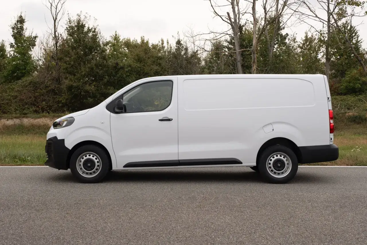 Furgoneta blanca Fiat Scudo aparcada en carretera con árboles al fondo. Conoce las fiat scudo medidas para tu negocio.