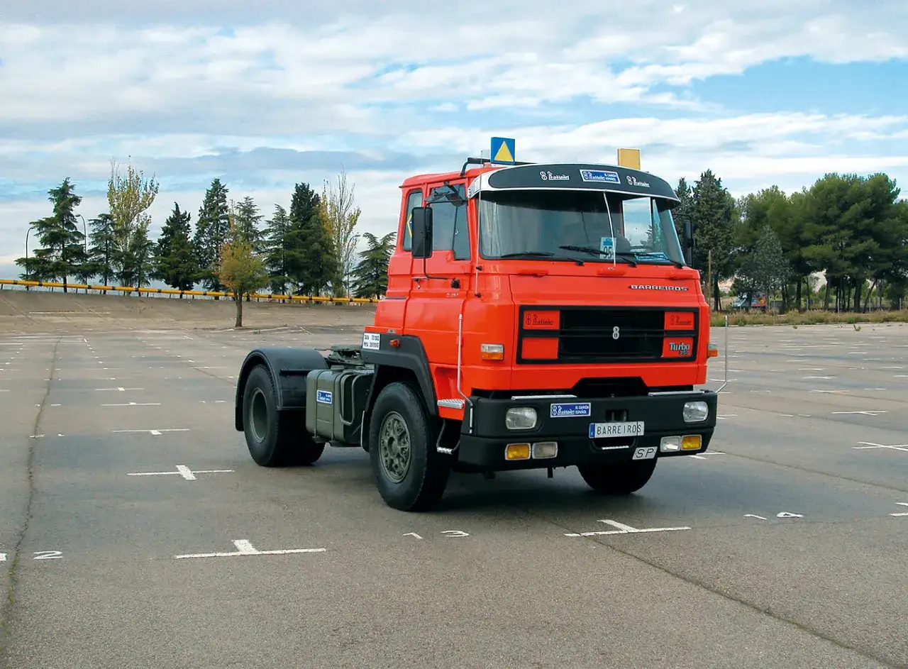 Cami&oacute;n Barreiros rojo en un aparcamiento vac&iacute;o. El veh&iacute;culo, un tractor de carretera, est&aacute; estacionado sobre asfalto con marcas blancas.