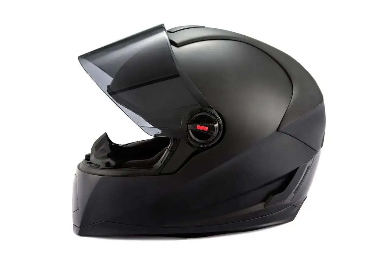 Casco negro mate de moto con visor oscuro levantado. Imprescindible para el uso obligatorio de casco en carretera.