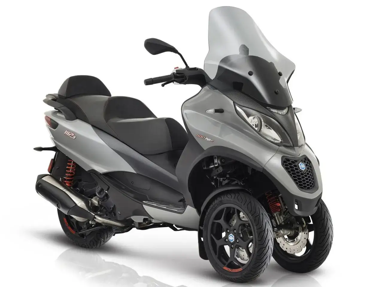 Un elegante triciclo de motor plateado con asiento negro y parabrisas alto.