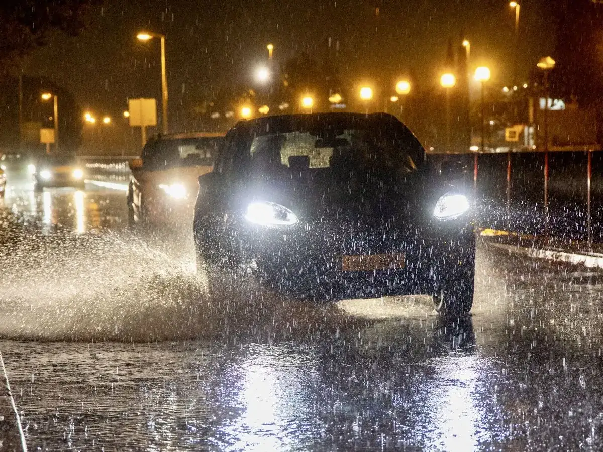 Coches circulan de noche por carretera mojada, levantando agua. &iquest;Qu&eacute; puede hacer para evitar el aquaplaning? Conduzca despacio.