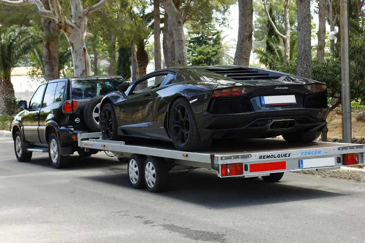 Un coche negro deportivo y un todoterreno negro en un remolque. ¿Qué remolque puedo llevar con el carnet B+E?