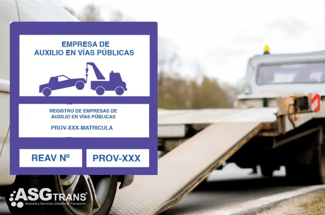 Placa de empresa de auxilio en v&iacute;as p&uacute;blicas, mostrando un cami&oacute;n gr&uacute;a y un coche. Detr&aacute;s, un cami&oacute;n de remolque listo para operar.